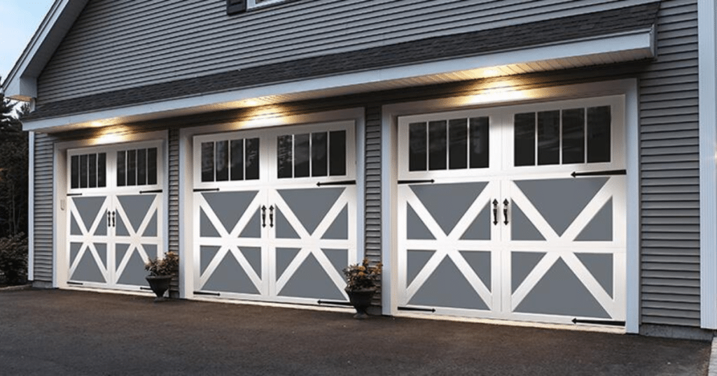 "Three-car garage with barn-style doors lit."