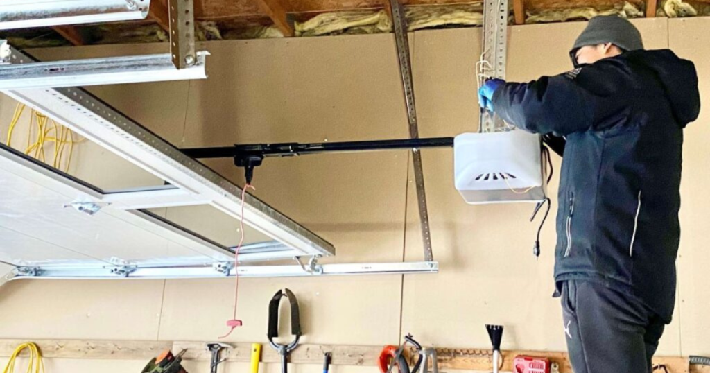 Technician installing a garage door opener.